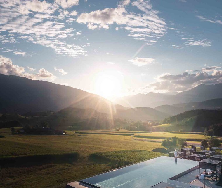 Programma di attività Tramonto su una valle montana con campi e piscina a sfioro