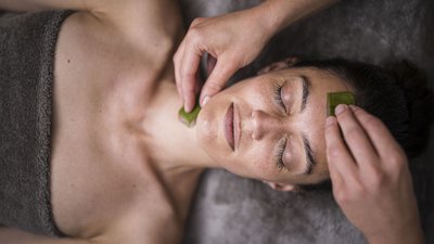 Donna rilassata durante trattamento viso con foglie di aloe vera