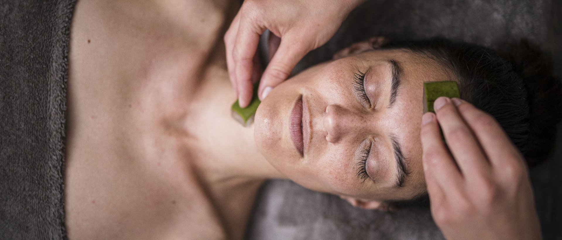 Donna rilassata durante trattamento viso con foglie di aloe vera