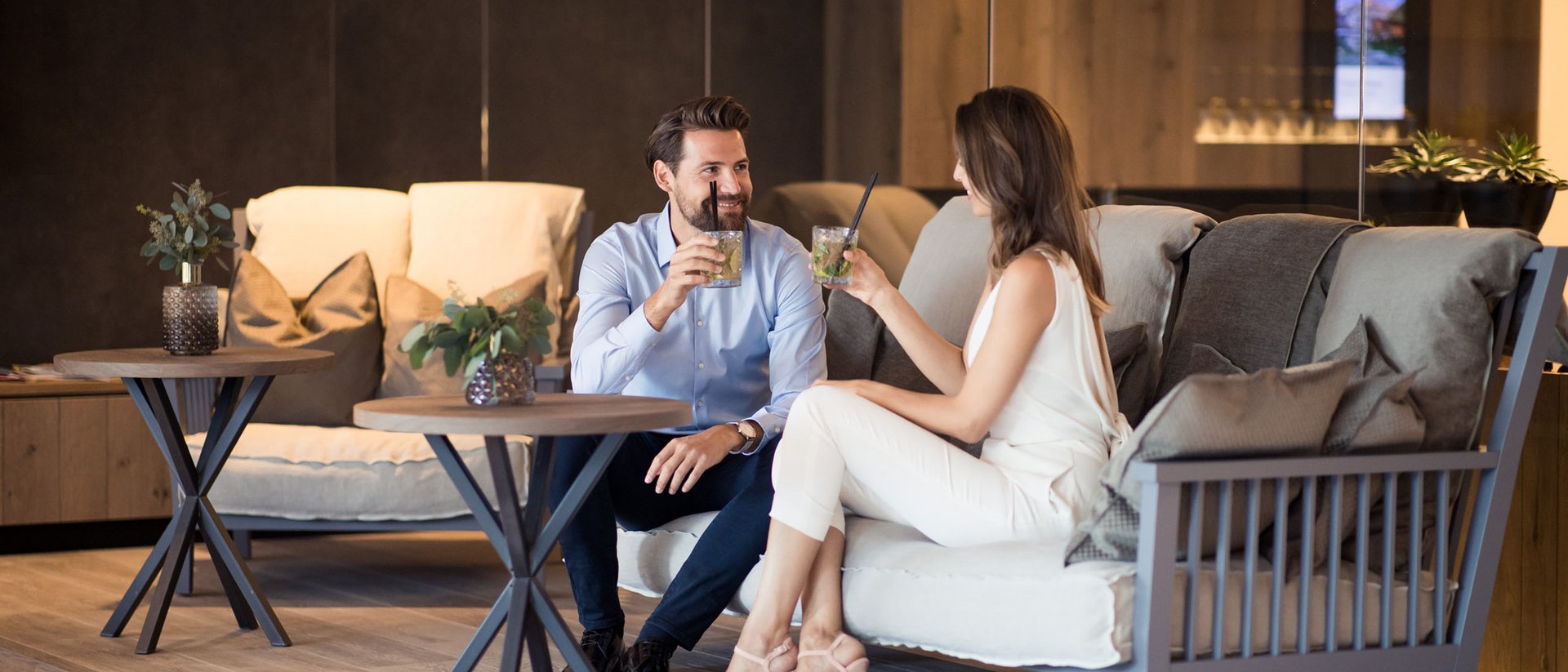 Coppia che beve cocktail e conversa in un moderno salotto