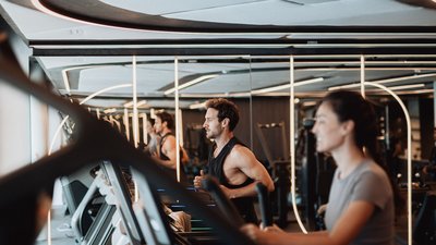 Man and woman exercising together on treadmills in a gym