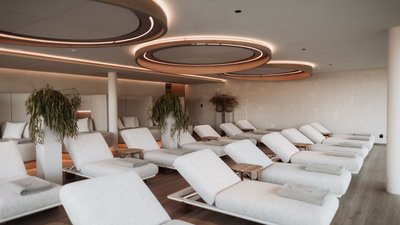 Modern relaxation room with light loungers and wooden ceiling lights