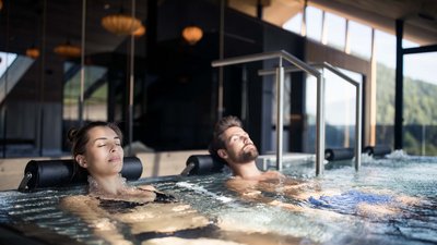 Coppia rilassata in una vasca idromassaggio moderna con vista sulla natura