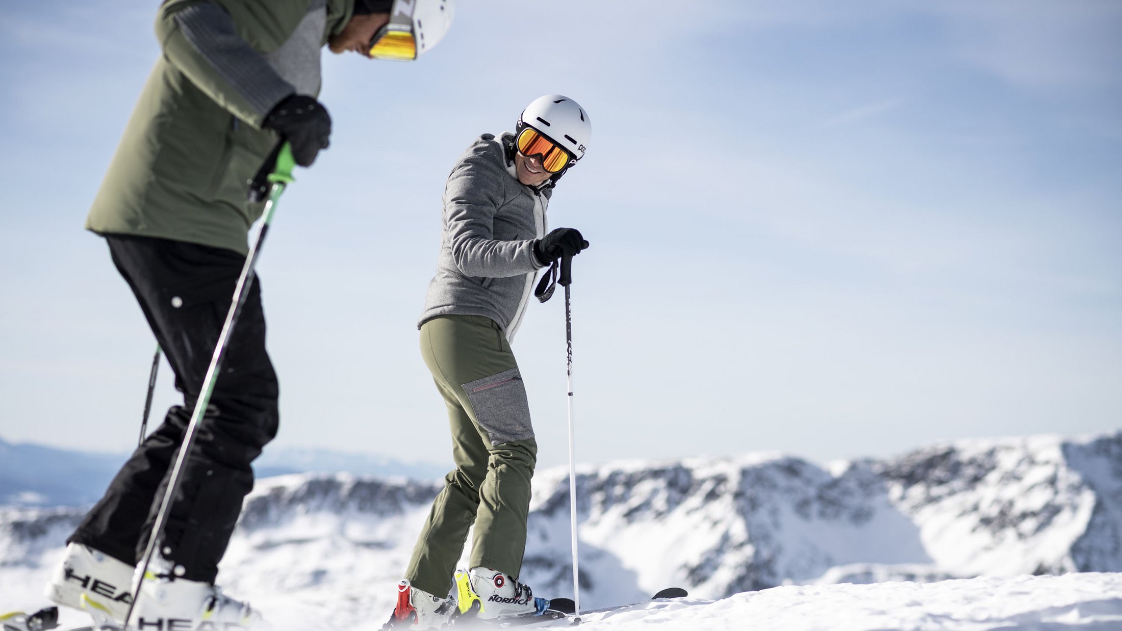 Due sciatori in abbigliamento invernale su una montagna innevata con cielo limpido