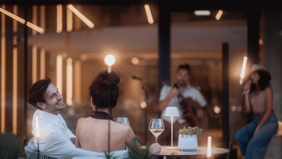 Photos from your hotel in Pfalzen in Val Pusteria/Pustertal Couple enjoying live music with wine and modern ambient lighting