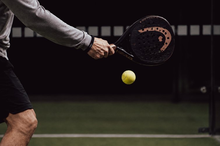 Tennis- & Padelurlaub in Südtirol: unser Premium-Service Nahaufnahme eines Padelspielers mit Schläger und gelbem Ball
