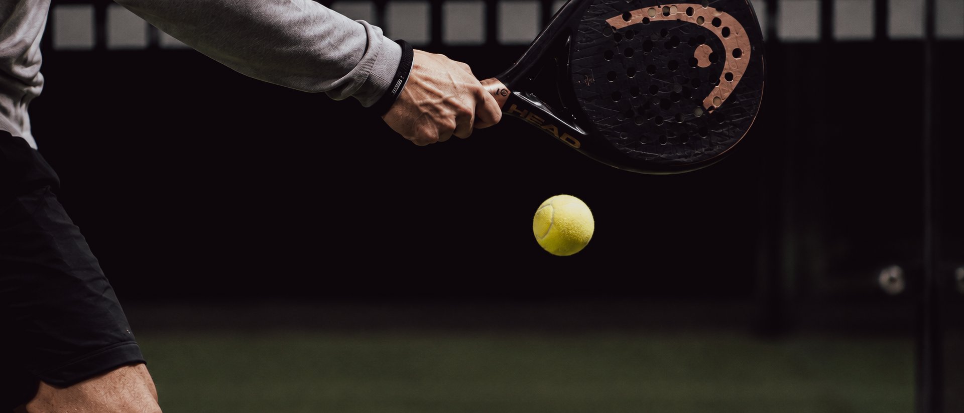 Tennis- & Padelurlaub in Südtirol: unser Premium-Service Nahaufnahme eines Padelspielers mit Schläger und gelbem Ball