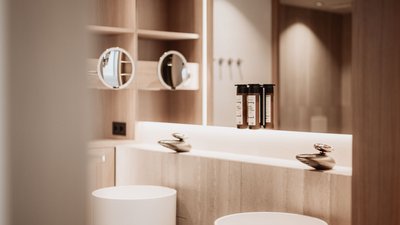 Modern bathroom mirror with cosmetic products and round mirrors