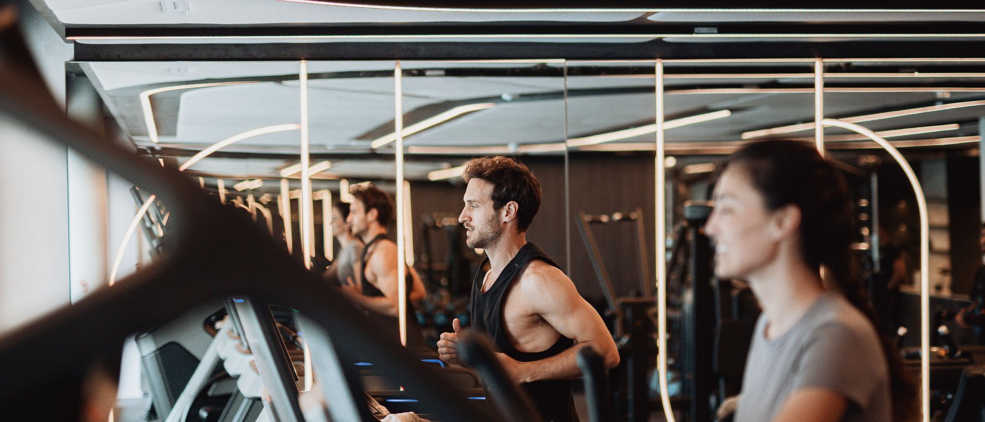 Uomo e donna che corrono sui tapis roulant in palestra