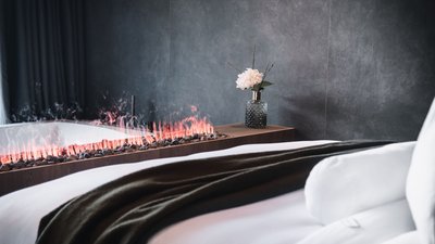 L’esclusività in foto: il nostro chalet in Alto Adige di lusso Camera da letto moderna con camino e vaso decorativo