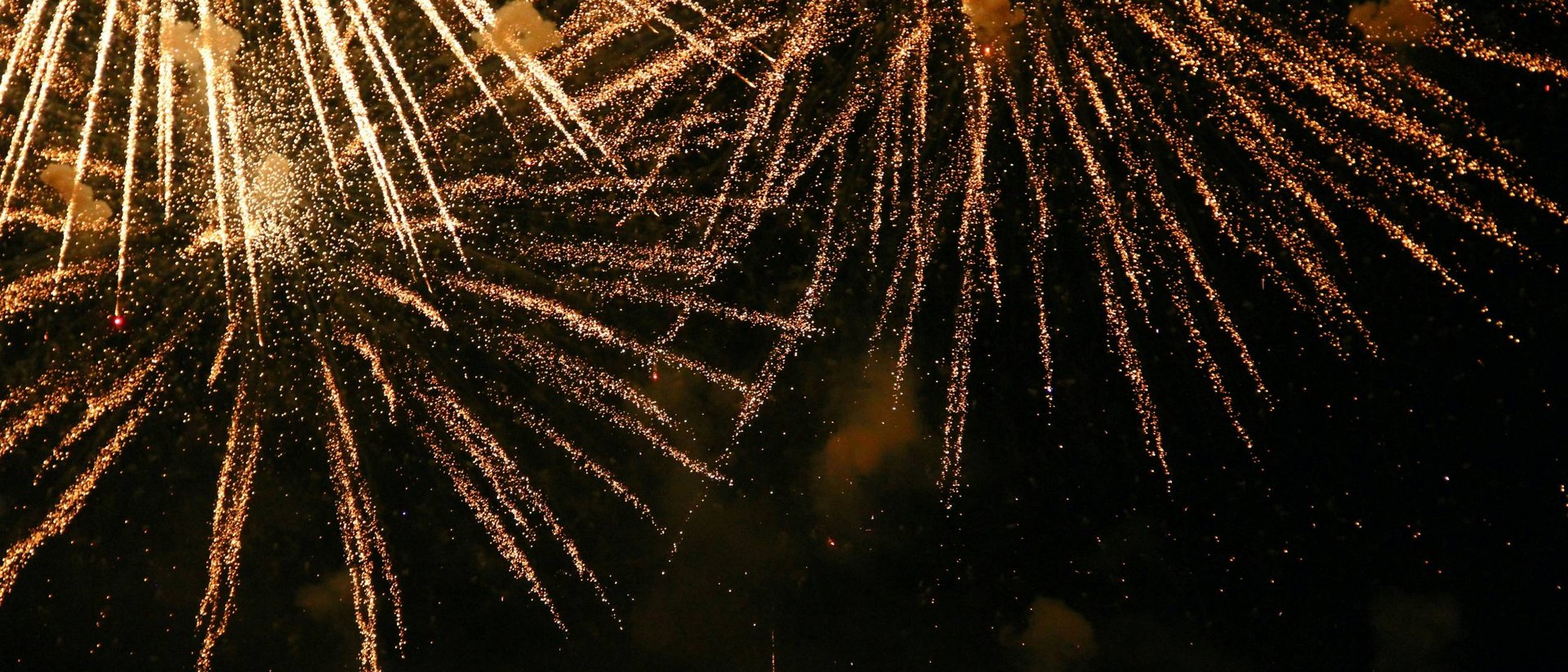 Jahreswechsel in den Alpen Goldene Feuerwerkslichter leuchten nachts am Himmel auf
