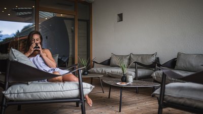 The best photos from our hotel in South Tyrol that kids love Woman relaxing on terrace holding a cup