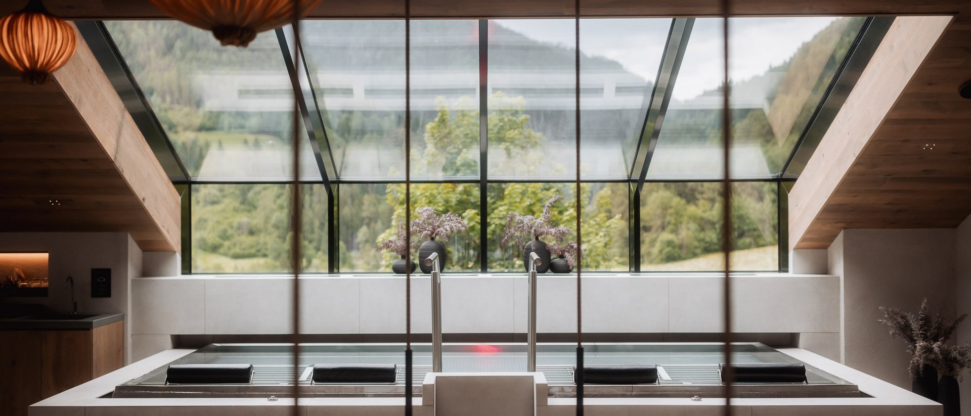 Modernes Wellnessbad mit großer Badewanne und Panoramafenster mit Bergblick