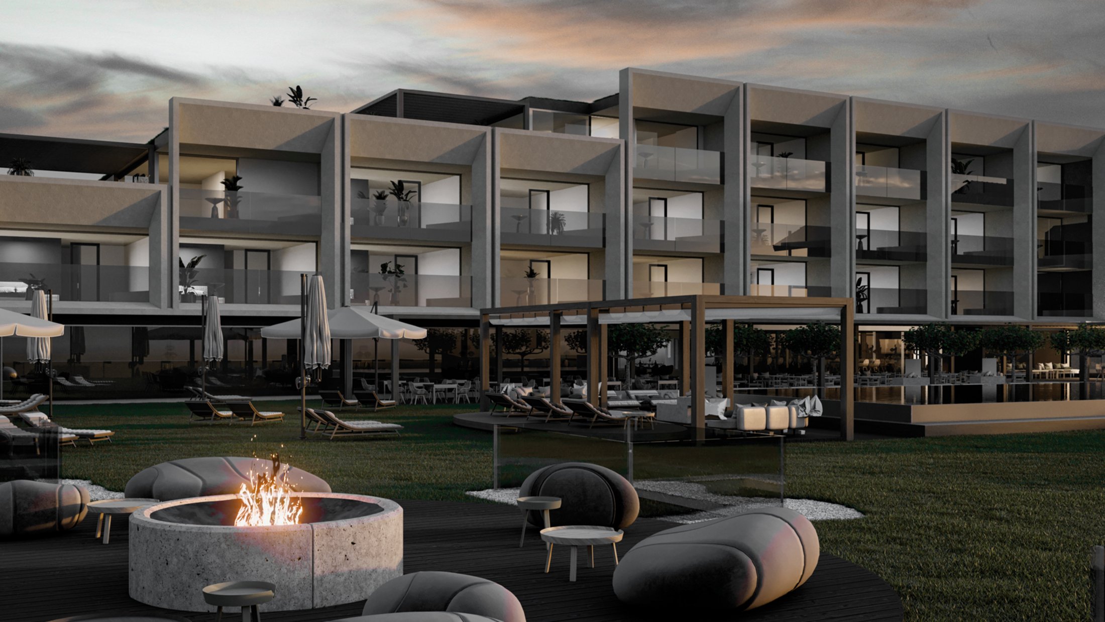 Moderne Hotelanlage mit Außensitzbereich und Feuerstelle bei Sonnenuntergang