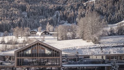L’esclusività in foto: il nostro chalet in Alto Adige di lusso Edificio moderno con piscina esterna riscaldata in paesaggio montano innevato