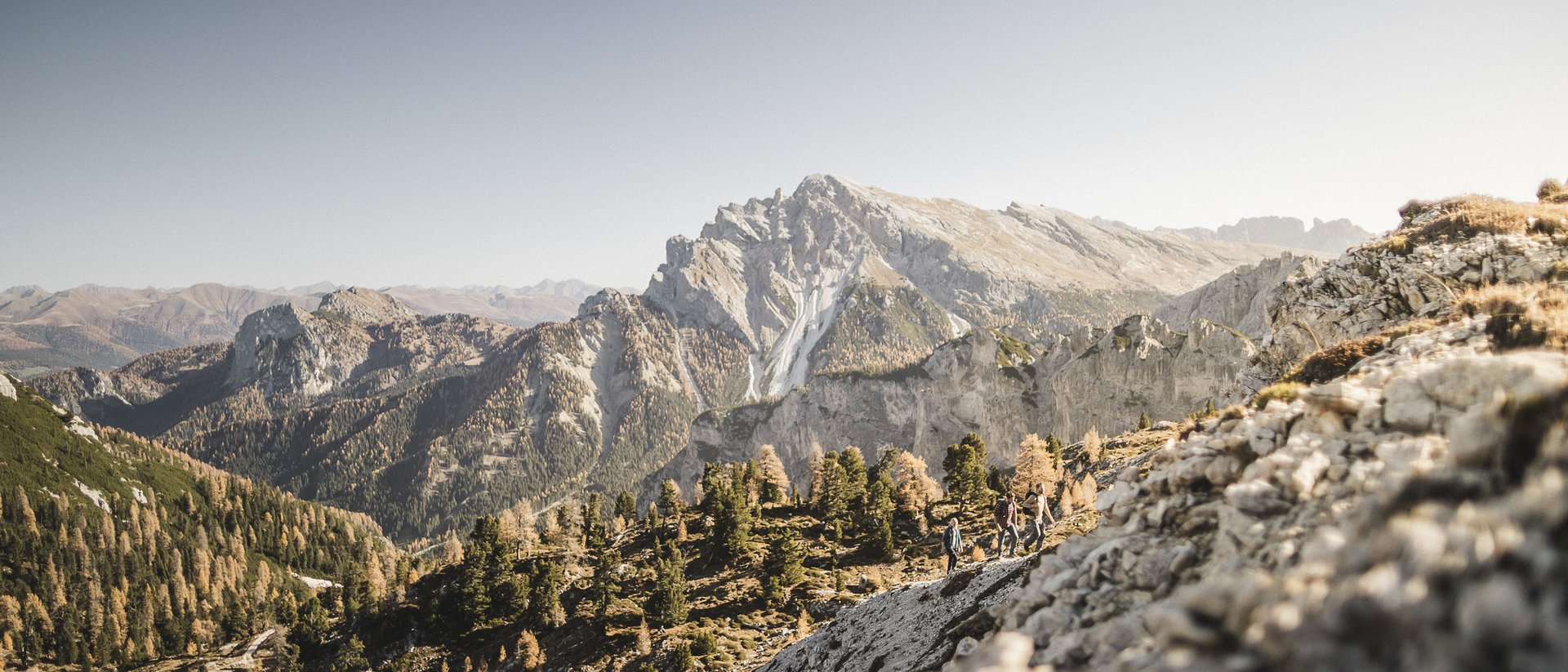Programma di attività Escursionisti su sentiero di montagna davanti a grandi rocce e bosco