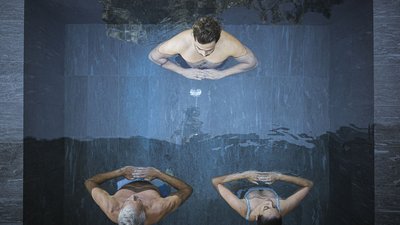 Tre persone che meditano insieme in una piscina viste dall'alto