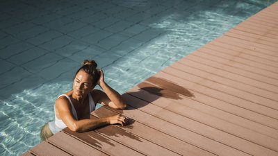 The best photos from our hotel in South Tyrol that kids love Woman relaxing at pool edge with wet hands on deck
