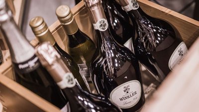 Cassetta di legno con bottiglie di vino e spumante