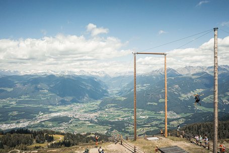 Large mountain swing with person and valley view in the Alps