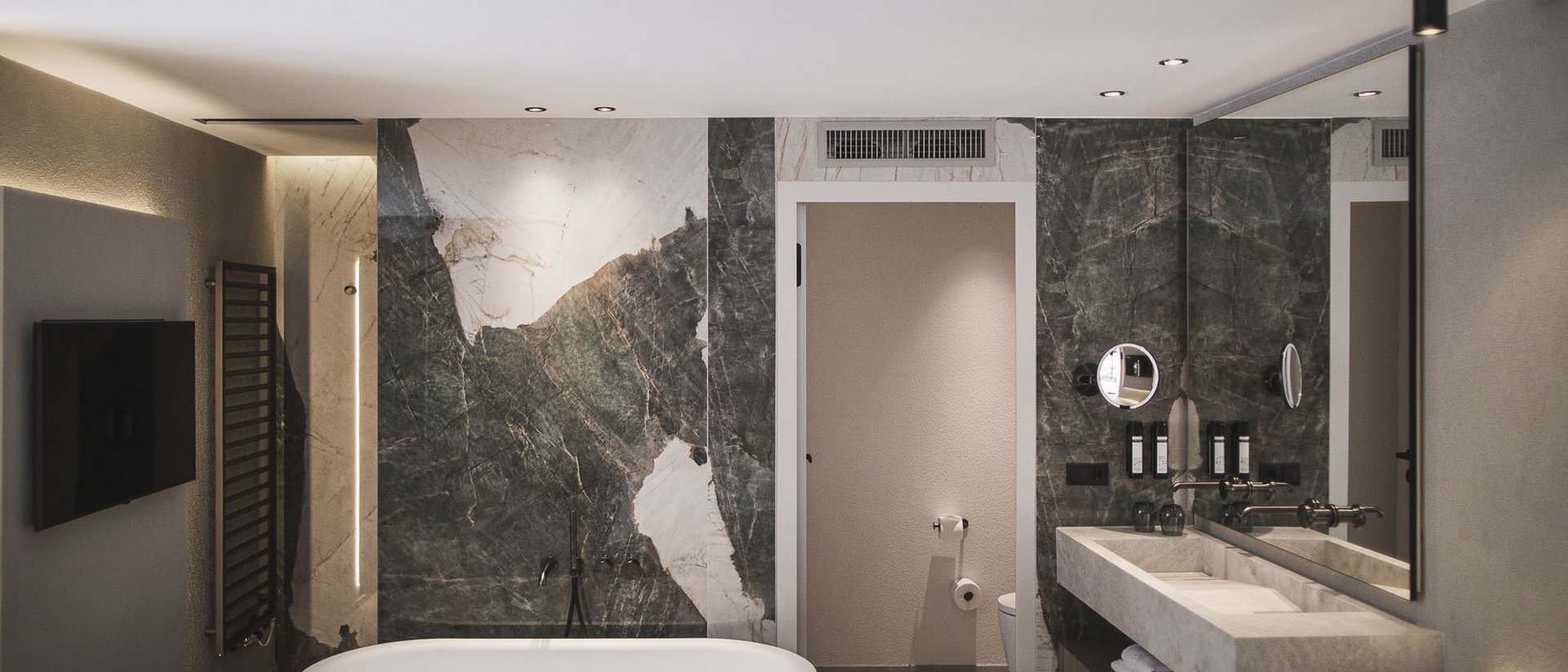 Bagno moderno con vasca da bagno freestanding e parete in marmo