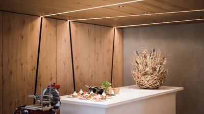 Cucina moderna con rivestimento in legno, banco, affettatrice e cesta decorativa