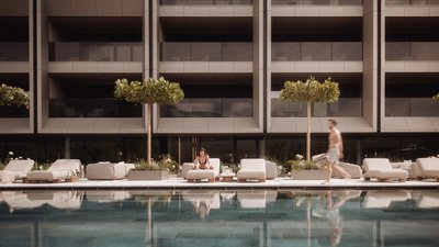 Photos from your hotel in Pfalzen in Val Pusteria/Pustertal People relaxing and walking by a modern hotel pool with loungers and trees
