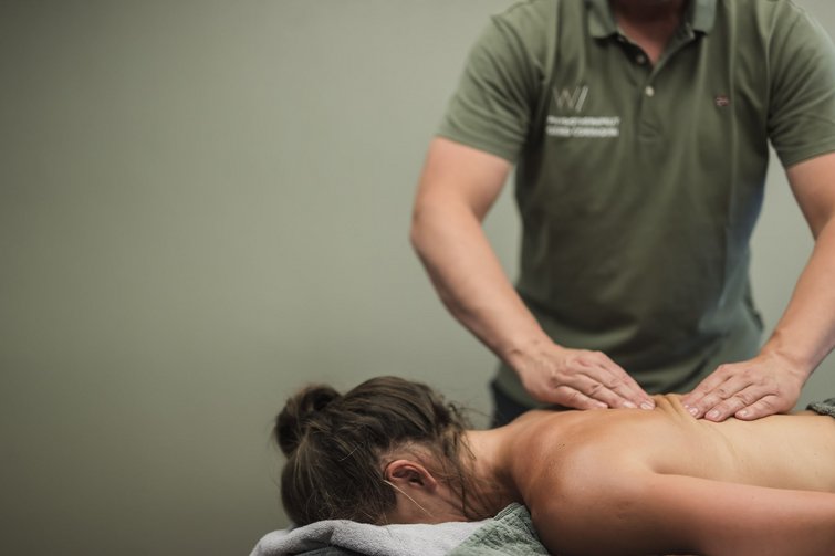 Persona che riceve un massaggio alla schiena da un massaggiatore con polo verde