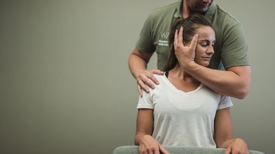 Fisioterapista che tratta una donna con terapia manuale al collo e spalle