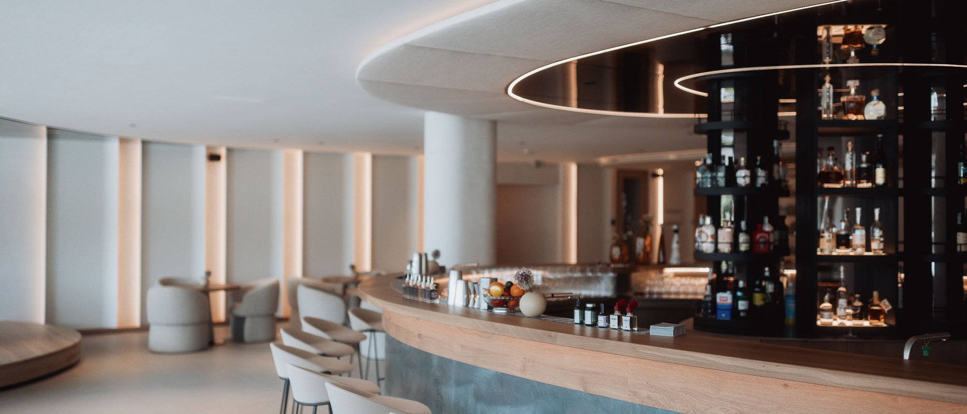 Die Heimat des Strahlens: Ihr Wellnesshotel in Südtirol Moderner Barbereich mit weißen Hockern und stilvollem Ambiente