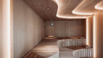 Modern wooden entrance with organically shaped benches and indirect ceiling lighting