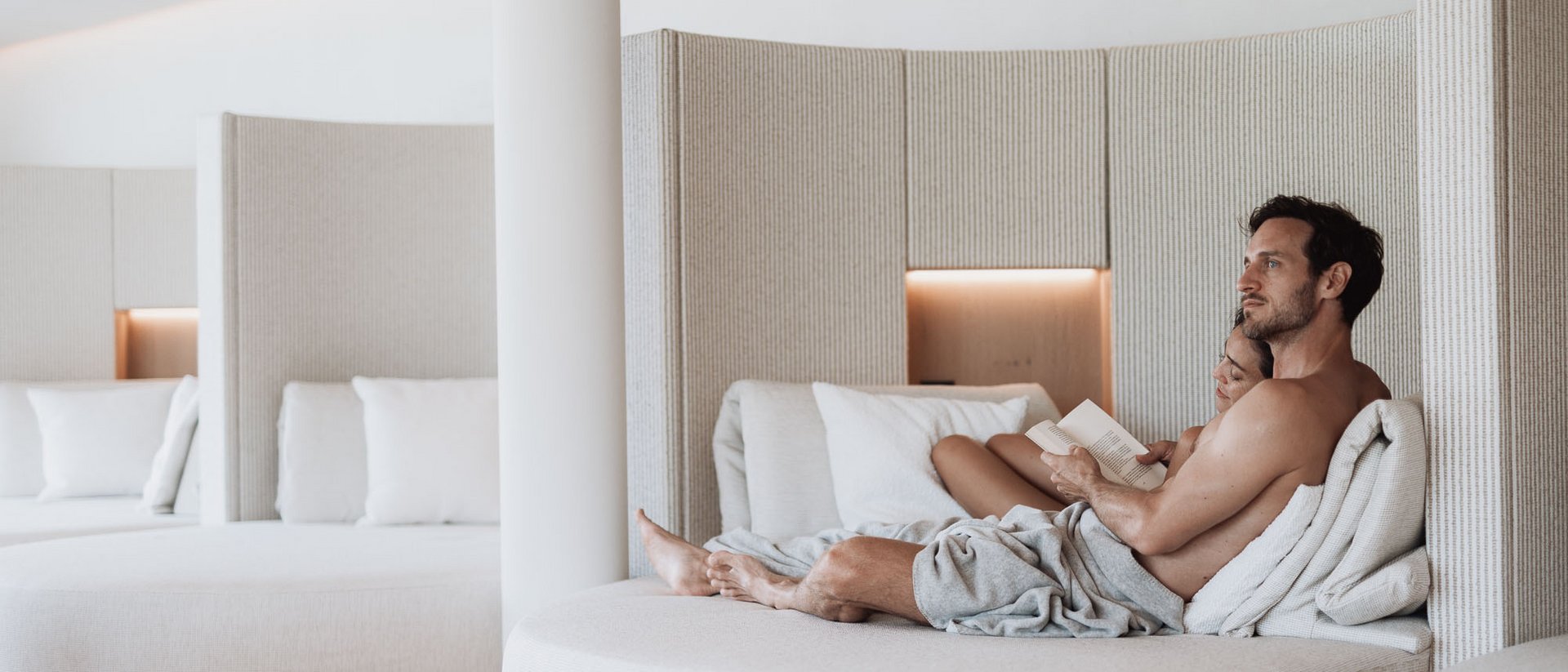 Paar entspannt sich auf einem modernen, runden Lounge-Sofa