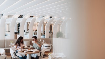 Photos from your hotel in Pfalzen in Val Pusteria/Pustertal Couple eating and drinking in modern restaurant with curved white ceiling arches