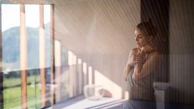 Donna con asciugamano in stanza luminosa, rilassata e serena