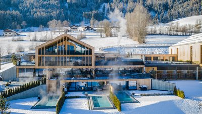 L’esclusività in foto: il nostro chalet in Alto Adige di lusso Hotel spa moderno con piscine all'aperto riscaldate in un paesaggio montano innevato