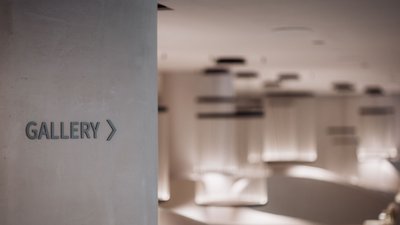 Wand mit Galerie-Schild und unscharfer moderner Innenraum im Hintergrund