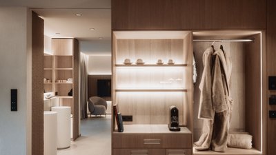 View of a modern minimalist room with wooden wardrobe and soft bathrobes