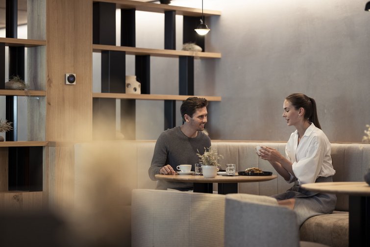 Man and woman chatting over coffee in a modern café