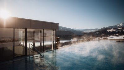 Steaming outdoor pool with mountain view at sunrise