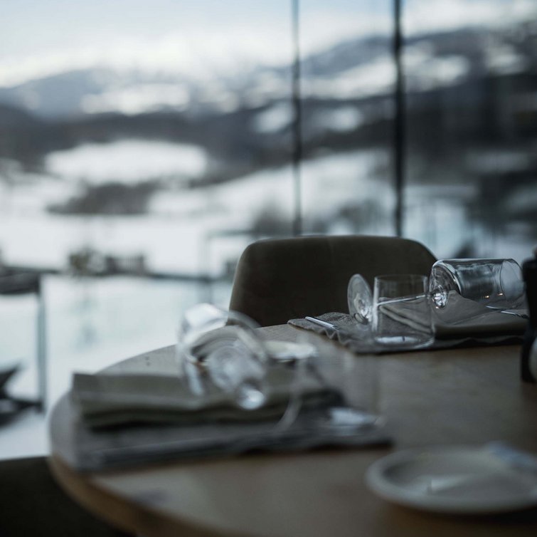 Gedeckter Tisch mit Glas und Bergblick im Hintergrund