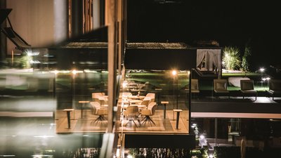 Ristorante moderno con sedie e tavoli e area esterna buia di notte