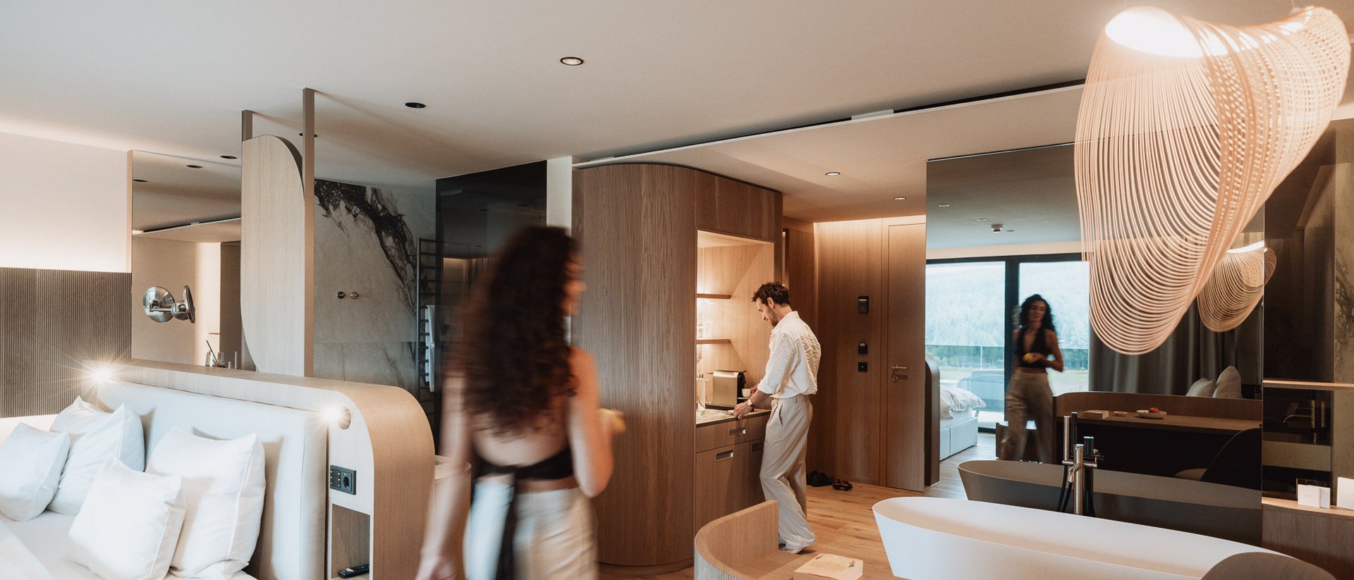 Moderne Hotelzimmer mit Badewanne, Schlafbereich und zwei Personen