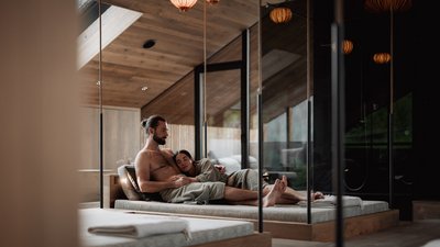 L’esclusività in foto: il nostro chalet in Alto Adige di lusso Coppia che si rilassa insieme in una spa moderna con elementi in legno
