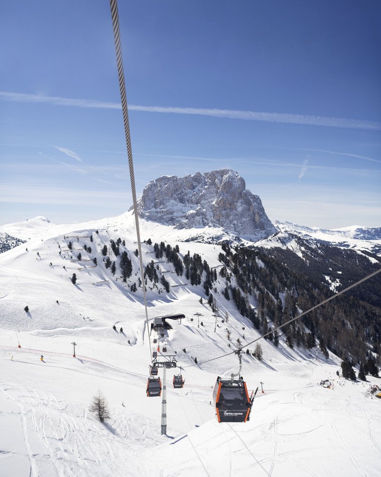 Seilbahn über schneebedecktes Skigebiet mit Berg im Hintergrund