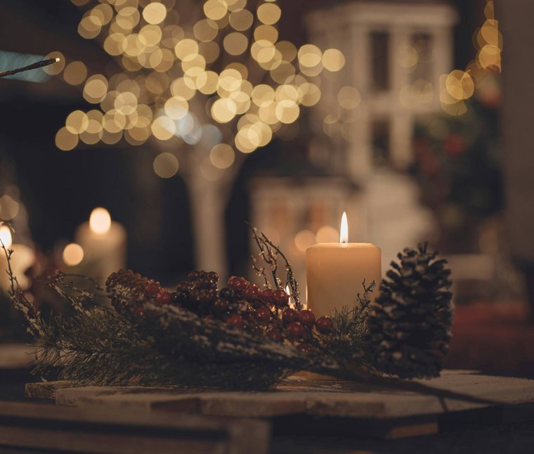 Winkler’s Stories: i nostri alberghi con maneggio di cavalli Candela accesa con pigna e bacche come decorazione natalizia