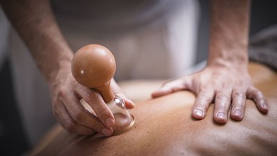 Massaggio con coppetta per terapia sul dorso di una persona