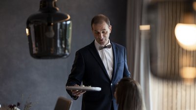 L’esclusività in foto: il nostro chalet in Alto Adige di lusso Cameriere che serve cibo in ristorante elegante