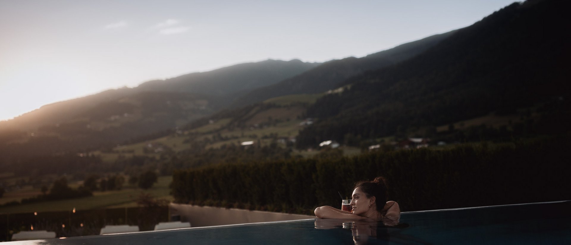 Hotel Solvie: Day Spa der Extraklasse Frau entspannt im Infinity-Pool mit Bergblick bei Sonnenuntergang