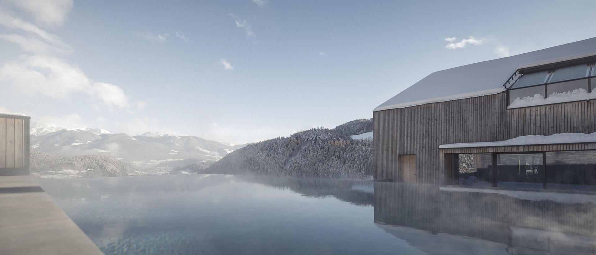 Infinity-Pool mit Bergblick und verschneitem Holzhaus unter blauem Himmel